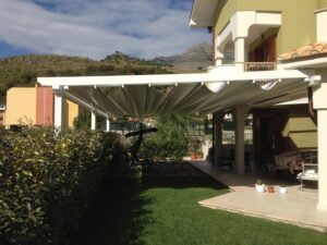 LAVORAZIONI 91 Porticato in alluminio 'essenza legno venato bianco', completo di tenda automatizzata in PVC a scomparsa.